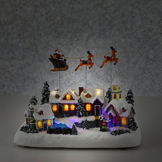 LED Winterlandschaft fliegender Santa Schlitten 29x22cm Polyresin bunte LEDs batteriebetrieben An-/Ausschalter Weihnachtsdekoration